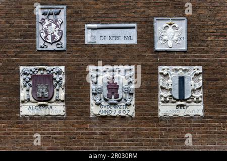 Alte Giebel an einer Wand mit Wappen in Amsterdam, Holland, Niederlande. Stockfoto