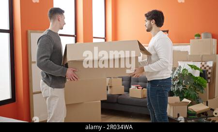 Zwei Männer, die Pappkartons in der neuen Wohnung halten Stockfoto