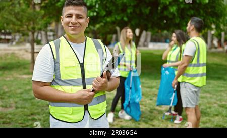 Eine Gruppe von Freiwilligen mit einem selbstbewussten Lächeln auf dem Klemmbrett im Park Stockfoto