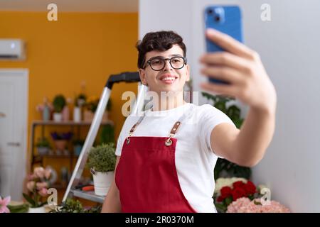 Nicht binärer männlicher Florist macht Selfie per Smartphone im Blumenladen Stockfoto