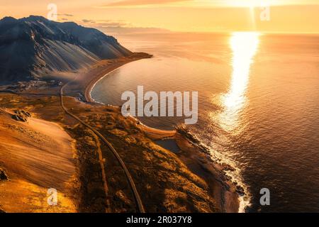 Luftaufnahme des wunderschönen Sonnenaufgangs über den vulkanischen Bergen in ländlicher Umgebung am Ozean der Halbinsel im Sommer in Island Stockfoto