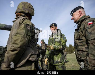 Rinkaby, Schweden. 06. Mai 2023. Der Oberbefehlshaber Schwedens, Micael Bydén (C), und der Oberbefehlshaber Polens, Rajmund Andrzejczak (R), unterhalten sich während der Militärübung der Aurora 23 am Schießstand Rinkaby außerhalb der Kristianstad am 06. Mai 2023 mit konskriptierten Panzerbesatzungen. Schwedische, polnische, amerikanische, finnische und dänische Truppen waren vor Ort, um den Feind zu bekämpfen, der das Hafengebiet um den Hafen von Ahus übernommen hatte.Foto: Johan Nilsson/TT/Code 50090 Kredit: TT News Agency/Alamy Live News Stockfoto