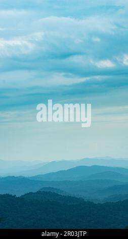 Ein wunderschöner Blick auf das bergige Gelände mit blauen Bergkämmen und sanften Hügeln Stockfoto