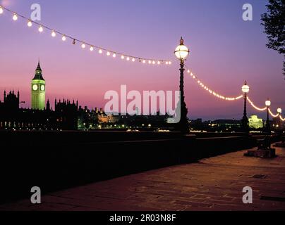 England. Nach London. Straßenlaternen am Themseufer bei Nacht mit Big Ben im Hintergrund. Stockfoto