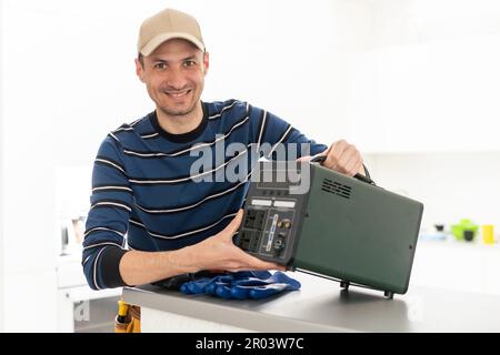 Ein Handwerker repariert eine tragbare Ladestation Stockfoto