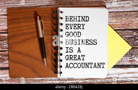 Finanzzitat hinter jedem guten Geschäft ist Ein großartiger Buchhalter, handgeschrieben auf einer gelben Haftnotiz auf der Laptop-Tastatur. Stockfoto