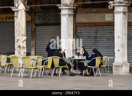 Eine kleine Gruppe Nonnen ruht im geschlossenen Caffè Lavena in der Arkade Procuratie Vecchie auf dem Markusplatz in Venedig, Venetien, Italien Stockfoto