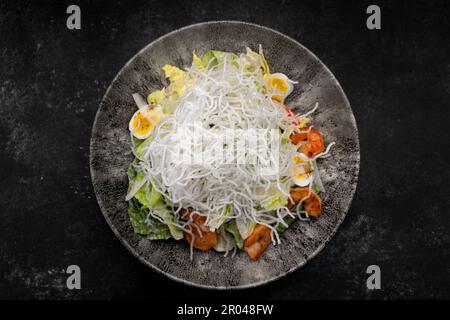 Caesar Salat mit gegrillten Garnelen und knusprigen Reisstäbchen Stockfoto