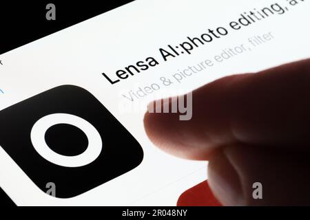 Die Lensa AI App wird im App Store auf dem iPad-Bildschirm angezeigt und zeigt mit dem Finger unscharf darauf. Selektiver Fokus. Stafford, Großbritannien, 6. Mai 2023 Stockfoto