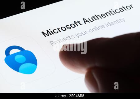 Die Microsoft Authenticator-App wird im App Store auf dem Bildschirm des ipads angezeigt und zeigt mit einem unscharfen Finger darauf. Selektiver Fokus. Stafford, Großbritannien, Mai Stockfoto