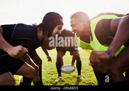 Rugby ist ein Sport mit hohem Kontaktaufkommen. Eine vielfältige Gruppe von Sportlern, die tagsüber während eines Rugbyspiels ein Scrum spielen. Stockfoto