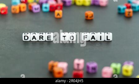 „Dare to Fail“-Slogan in weißen Blockperlen. Motivation Inspiration Aufmunterung Konzept Stockfoto