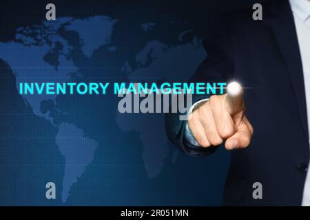 Mann berührt virtuellen Bildschirm mit Text Inventory Management auf farbigem Hintergrund Stockfoto