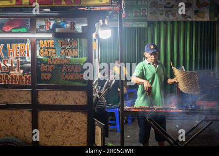 Akarta, Indonesien - 29. April 2023: Ein unbekannter Mann, der traditionelle indonesische Speisen auf der Straße in Jakarta, Indonesien, zubereitet und verkauft. Stockfoto