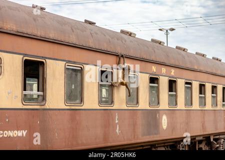 Ein Pavian bereitet sich darauf vor, in einem Zug, der am Bahnhof Victoria Falls in Simbabwe angekommen ist, Essen zu sammeln Stockfoto