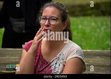 Porträt einer reifen Frau, die in der Natur raucht Stockfoto