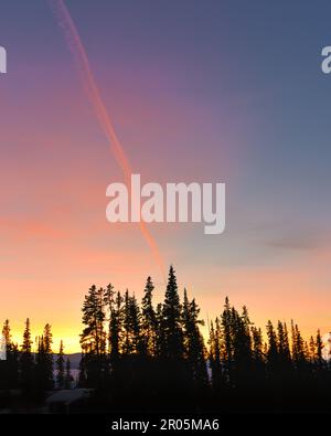 Unglaubliche Sonnenuntergänge in der Wintersaison vom Norden Kanadas mit leuchtend rosa Wolken, Bergen und Schnee in der Dämmerung. Stockfoto