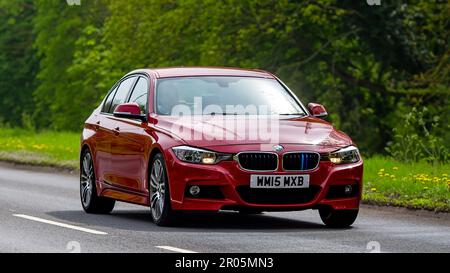 Stony Stratford, Bucks, Großbritannien - April 30. 2023. Roter 2015-Dieselmotor, BMW 3-Serie, Fahrt auf einer englischen Landstraße. Stockfoto