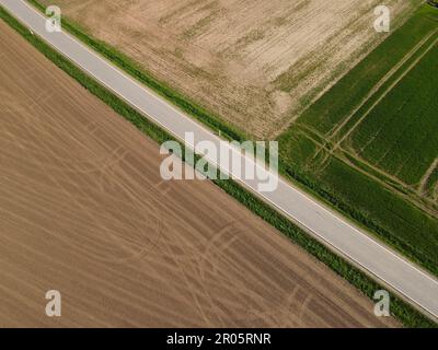 Luftaufnahme einer Straße zwischen den Landwirtschaftsfeldern im Frühjahr Stockfoto