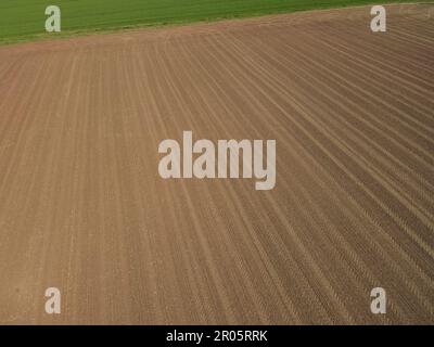 Luftaufnahme des gepflügten Ackerfeldes mit Erde im Frühling Stockfoto