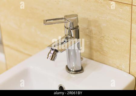 Bidet-Wasserhahn aus Edelstahl im Badezimmer Stockfoto
