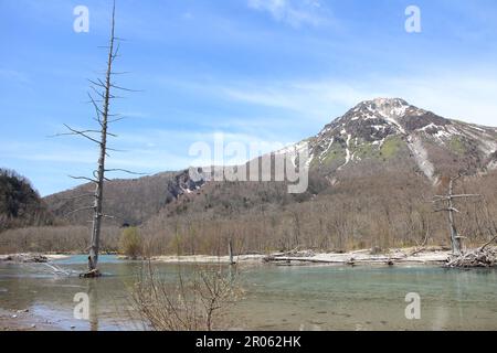 Taisho-ike-Teich und schneebedeckter Mount Yakedake in Kamikochi, Japan Stockfoto