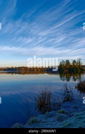 Clunie Loch an einem WinterÕs-Tag im Dezember, an dem die peitschenden Cirrus-Wolken über dem Wasser reflektieren. Stockfoto