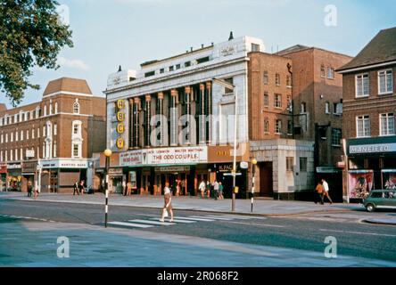 Das ABC-Kino, Uxbridge Road, Ealing, London 1968. Der Film war „das seltsame Paar“ mit Jack Lemmon und Walter Matthau. Eine Frau überquert eine Fußgängerzone der „Zebra“. Das 1934-Kino war ursprünglich das Forum Theatre. Es wurde von Associated British Cinemas (ABC) übernommen. Entworfen von Stanley Beard mit einer Art déco-Fassade, die von acht Säulen im ägyptischen Stil dominiert wird. Es wurde 1961 in ABC umbenannt. Ein noch nicht vollendetes Projekt, das zu Ealing Filmworks wurde, bedeutete, dass der Großteil des Gebäudes abgerissen wurde, aber die Fassade wurde 2020 restauriert – ein altes Foto aus dem Jahr 1960er. Stockfoto