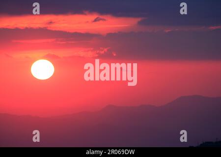 Orangefarbenes Licht des Sonnenuntergangs über dem Berg Stockfoto