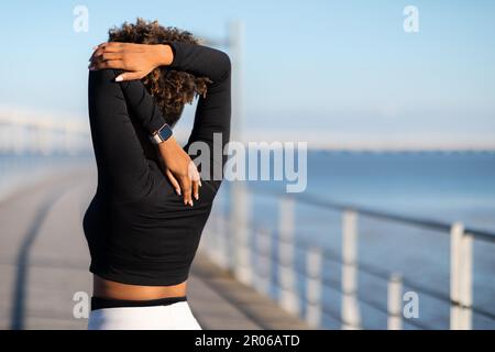 Unbekannte Schwarze Frau, Die Sich Im Freien Streckt Und Sich Auf Das Fitness-Workout Vorbereitet Stockfoto
