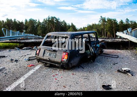 Auf der Lyman-Straße wurde ein ziviles Auto von russischen Soldaten vor der Brücke zerstört, die absichtlich von der ukrainischen Armee in die Luft gesprengt wurde, um sie zu verhindern Stockfoto