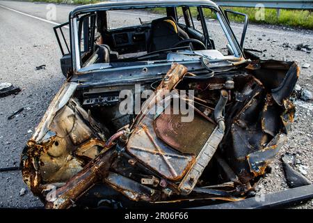 Auf der Lyman-Straße wurde ein ziviles Auto von russischen Soldaten vor der Brücke zerstört, die absichtlich von der ukrainischen Armee in die Luft gesprengt wurde, um sie zu verhindern Stockfoto