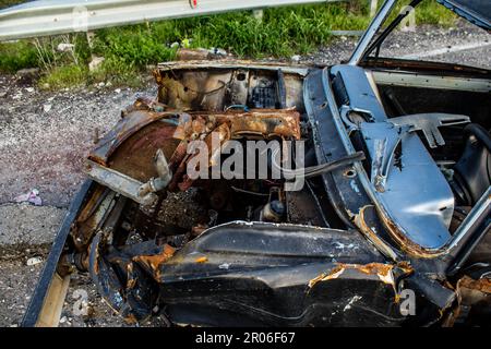 Auf der Lyman-Straße wurde ein ziviles Auto von russischen Soldaten vor der Brücke zerstört, die absichtlich von der ukrainischen Armee in die Luft gesprengt wurde, um sie zu verhindern Stockfoto