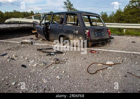 Auf der Lyman-Straße wurde ein ziviles Auto von russischen Soldaten vor der Brücke zerstört, die absichtlich von der ukrainischen Armee in die Luft gesprengt wurde, um sie zu verhindern Stockfoto