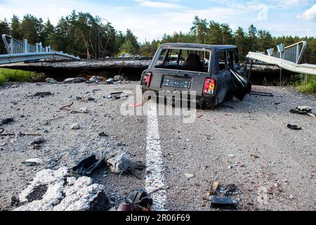 Auf der Lyman-Straße wurde ein ziviles Auto von russischen Soldaten vor der Brücke zerstört, die absichtlich von der ukrainischen Armee in die Luft gesprengt wurde, um sie zu verhindern Stockfoto