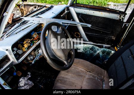 Auf der Lyman-Straße wurde ein ziviles Auto von russischen Soldaten vor der Brücke zerstört, die absichtlich von der ukrainischen Armee in die Luft gesprengt wurde, um sie zu verhindern Stockfoto