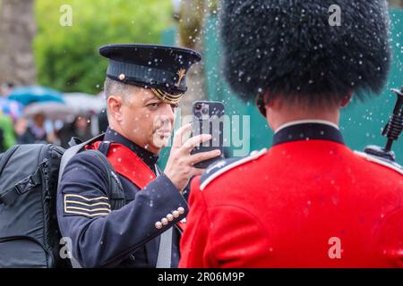 The Mall, London, Großbritannien. 6. Mai 2023 Ein Mitglied der britischen Streitkräfte auf der Parade in der Mall schüttelt die Regentropfen von seinem Bärenfell-Hut für ein Foto nach der Prozession zur Krönung von König Karl III Foto: Amanda Rose/Alamy Live News Stockfoto