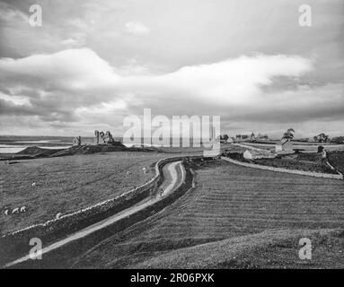 Ein Blick aus dem späten 19. Jahrhundert auf Clonmacnoise, ein zerstörtes Kloster in der Grafschaft Offaly in Irland am Fluss Shannon. Saint Ciarán gründete das Kloster im Jahr 544, wo die wichtigste Ost-West-Landstraße auf den Fluss Shannon trifft. Die strategische Lage des Klosters half ihm, ein wichtiges Zentrum der Religion, des Lernens, der Handwerkskunst und des Handels im 9. Jahrhundert zu werden. Von den Neunten wurden viele der hohen Könige von Tara und Connacht hier begraben. Sie wurde Ende des 13. Jahrhunderts verlassen und hinterließ Ruinen, eine Burg, zwei runde Türme und eine große Anzahl von Steinkreuzen. Stockfoto