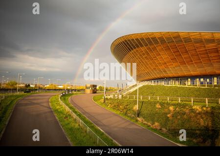 Über dem Velodach (Pringle) im Queen Elizabeth Olympic Park in Newham, London, ist ein Regenbogen zu sehen. Graue Wolken, England, Großbritannien. Stockfoto