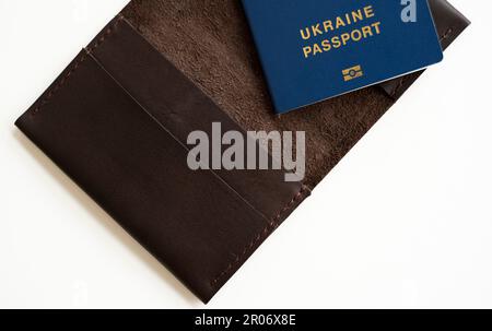 Ukrainischer biometrischer reisepass-id auf einer Lederpasshülle für Reisen durch Europa ohne Visum auf dem Tisch. Aufnahme in den ukrainischen ukrainischen Pass Stockfoto