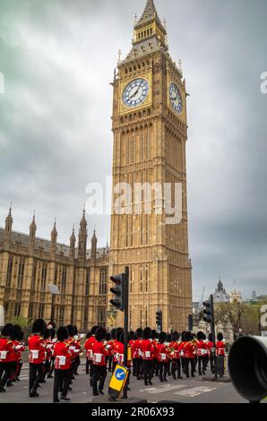 Während sie in vollen Zeremonialkostümen an den Houses of Parliament und Big Ben vorbeimarschieren, spielt eine Band der Grenadiergarde der Bristischen Armee Mus Stockfoto