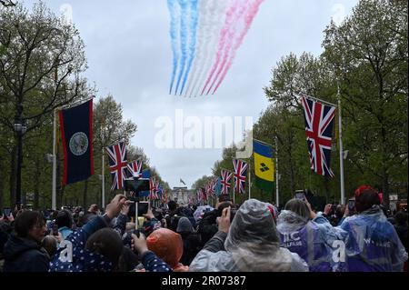 Die Menschenmassen beobachten, wie die Roten Pfeile nach der Krönung von König Karl III. Und Königin Camilla in London an der Fliegengeschichte teilhaben, während sie über die Mall fliegen. Foto: Samstag, 6. Mai 2023. Stockfoto