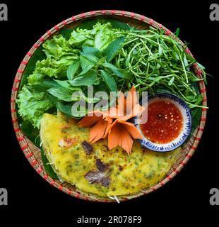 Vietnamesischer Pfannkuchen Banh Xeo mit Meeresfrüchten auf schwarzem Hintergrund mit Blick von oben Stockfoto