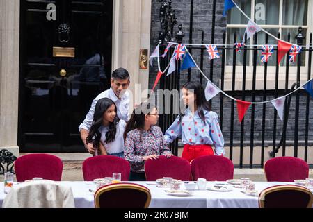 London UK. 7. Mai 2023 Premierminister Rishi Sunak (L) und seine Frau Akshata Murty (R) werden von den Töchtern und (L) Anoushka und Krishna (R) begleitet, die vor der Downing Street ein großes Mittagessen zur Krönung für Helden aus der Gemeinde, ukrainische Familien, die aus dem Krieg geflohen sind, und Jugendgruppen in London ausrichten. Die Veranstaltung findet im Rahmen des „Big Lunch“ statt, einer landesweiten Initiative, die Nachbarn und Gemeinschaften zusammenbringt, um die Krönung von König Karl III. Und Königin Camilla zu feiern. Über 50.000 Straßenparitäten werden voraussichtlich im gesamten Vereinigten Königreich stattfinden. Credit: amer Gazzal/Alamy Live News Stockfoto