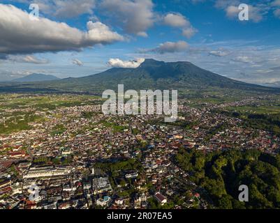 Luftdrohne der Stadt Bukittinggi und des Berges Marapi. Ein Uhrenturm, Jam Gadang. Sumatra. Indonesien. Stockfoto