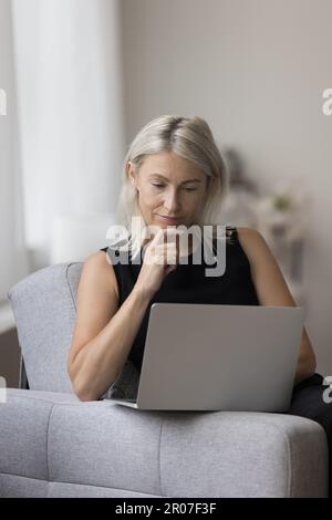 Rücksichtsvolle leitende Freiberuflerin, die von zu Hause aus mit einem Laptop arbeitet Stockfoto