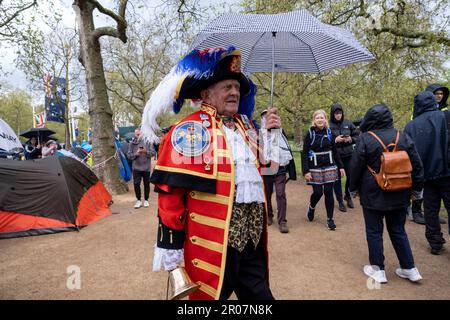 Royalist Town Crier als Schutz vor sintflutartigen Regenfällen entlang der Mall in Vorbereitung auf die Krönung von König Karl III am 5. Mai 2023 in London, Großbritannien. Viele sind bereit, über Nacht zu zelten und tragen zur Feier rot-weiß und blau die Flagge der Union, bevor König Karl III. Zum König von England gekrönt wird. Stockfoto