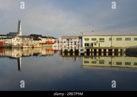 Fischerboote, Gebäude und Kirche spiegeln sich im glatten Wasser eines Hafenbeckens, Eismeerkathedrale, Vardoe, Varanger Halbinsel, Finnmark Stockfoto