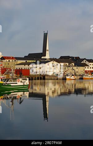 Fischerboote, Gebäude und Kirche spiegeln sich im glatten Wasser eines Hafenbeckens, Eismeerkathedrale, Vardoe, Varanger Halbinsel, Finnmark Stockfoto