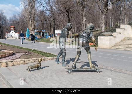 Chisinau, Moldawien - 9. März 2023: Skulptur von Skateboardern mit Basset-Hund-Skulptur von Petru Glavan. Stockfoto